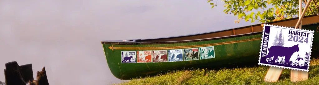 canoe on shore with several habitat stamps on it