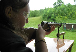 view of a woman looking down the barrel of a firearm