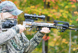 Woman taking aim with a crossbow